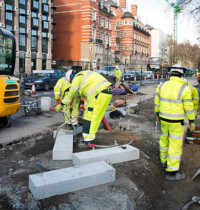 London, England - January 16, 2016: Construction workers creating new cycle lanes on the Embankment in London. The project - known as the Cycle Superhighway - has been causing chaos for traffic and pedestrians and is planned to be the longest segregated cycle route in Europe.
